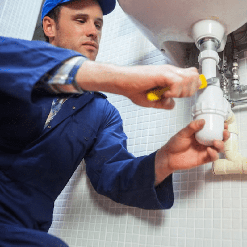 frowning plumber repairing sink